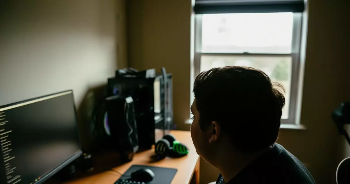 Gamer taking a visual break by looking out a window away from their gaming monitor
