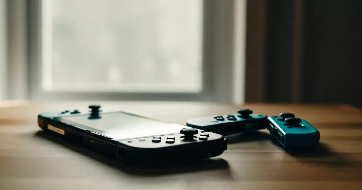 Nintendo Switch console and Joy-Con controllers on a wooden desk