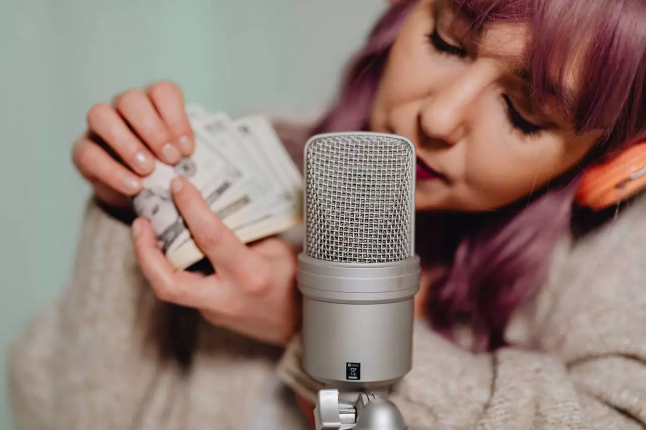Content creator holding microphone and money representing revenue splits between Twitch and Kick in 2026